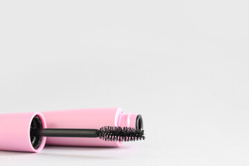 Black mascara on grey background, closeup