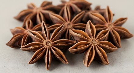 A close-up shot of several star anise pods, showcasing their distinctive star shape and brown, woody texture.