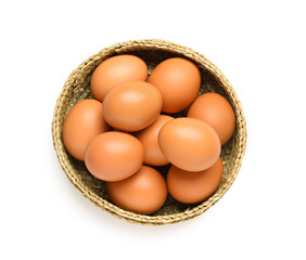 Wicker bowl with brown chicken eggs on white background