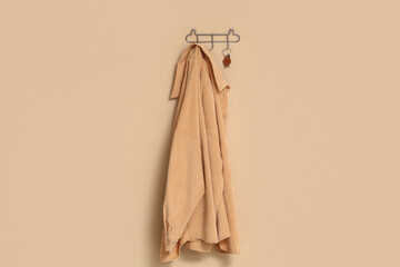 Key from house and clothes hanging on hooks on beige wall