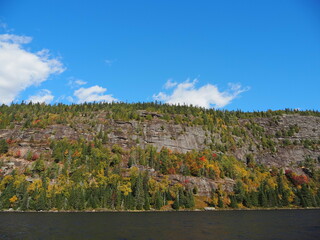 Rock cliffs and autumn forest by the lake in Sept-Chutes Regional Park, Quebec