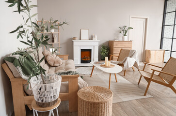 Cozy interior of living room with fireplace, armchairs, sofa and table