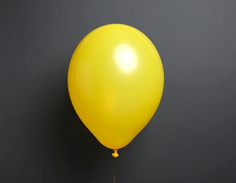 Single yellow balloon against a gray backdrop