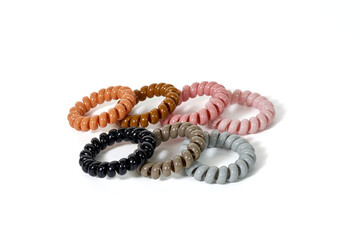 A collection of colorful spiral hair ties, a modern and gentle hair accessory, isolated on a white...