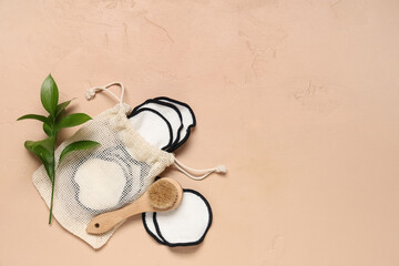 Composition with bag, reusable cotton pads and massage body brush on beige background