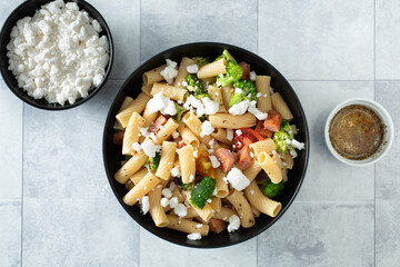 A top down view of a bowl of gluten-free rigatoni pasta salad.