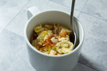 A view of a ceramic mug of instant breakfast bowl.
