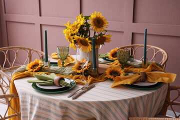 Elegant table serving with plates, candles and beautiful sunflowers
