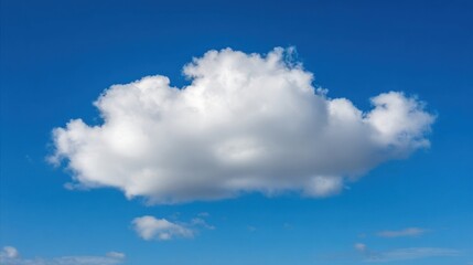 A clear blue sky features a fluffy white cloud with slightly pink edges, bathed in sunlight against a vibrant backdrop.