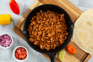 A top down view of chicken chorizo meat in a cast iron skillet.