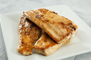 A closeup view of a plate of pan-fried mahi mahi fillets.