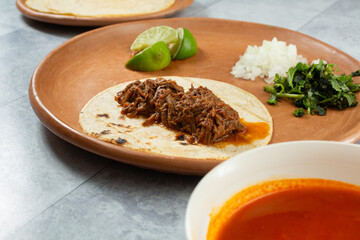 A view of a beef birria taco, on a plate.