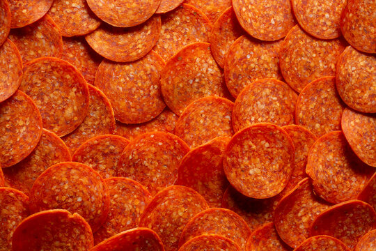 A top down view of a pile of pepperoni slices, as a background.
