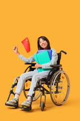Obraz premium Young Asian woman in wheelchair with flag of China and folders on yellow background