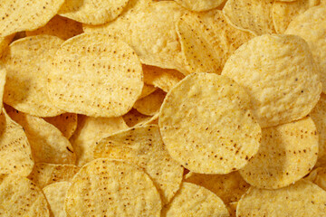 A top down view of a pile of round tortilla chips, as a background.