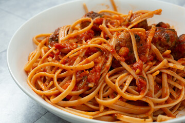 A view of a bowl of gluten-free linguine and meatballs.
