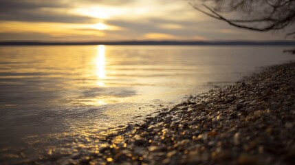 A serene sunset over a tranquil lake with golden reflections, rocky shore, pebbles,