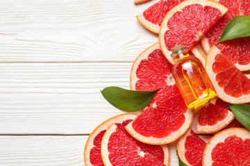 Grapefruit essential oil on white wooden background