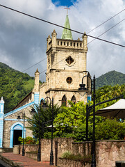 View of Soufri&egrave;re town with colorful houses at the foot of the volcanic Piton mountain in Saint Lucia, Caribbean. Scenic tropical landscape with lush green hills and blue ocean coastline.