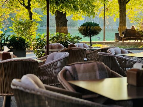 A cozy restaurant in Uzhgorod with a view of the Uzh River and autumn linden trees with yellowing leaves,  Ukraine 