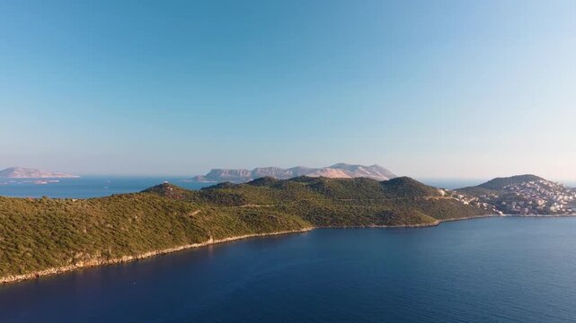 aerial perspective captures the stunning turquoise waters and lush coastline near Kas, Turkey, with the picturesque Greek island of Kastellorizo Meis visible on the horizon under a clear blue sky.