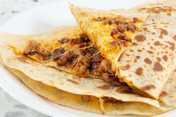 A closeup view of an al pastor quesadilla.