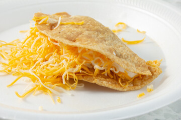 A closeup view of a hard taco, on a plate.