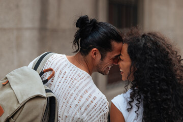 Tourists couple laughing and rubbing noses in a romantic moment during their vacation