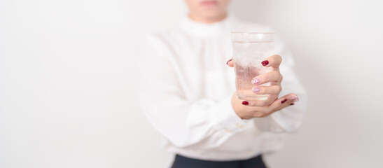 Business woman having Tremor hand during hold water glass. Parkinson disease April awareness month,...