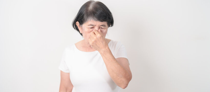 Elderly Woman having Nose pain for concepts of Nose disease, Common Cold, Influenza, Flu, Covid 19, Respiratory Infection, Sinusitis, Allergic Rhinitis, Asthma, Allergy, Dry nose Anosmia and Health