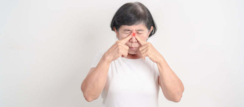 Elderly Woman having Nose pain for concepts of Nose disease, Common Cold, Influenza, Flu, Covid 19, Respiratory Infection, Sinusitis, Allergic Rhinitis, Asthma, Allergy, Dry nose Anosmia and Health