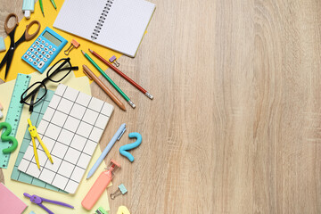 School supplies, eyeglasses and blank open notebook on wooden background, closeup