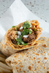 A closeup view of a carne asada burrito.