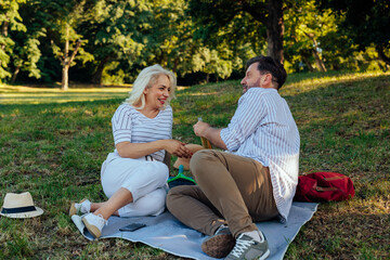 Fototapeta premium Senior Couple Enjoying Picnic and Sharing Stories in the Park