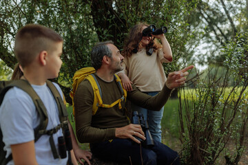 Family exploring nature with binoculars during hiking trip