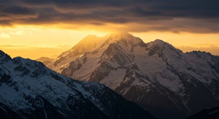 Snowcapped mountains at golden hour with sunburst effect