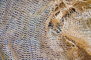 Elegant openwork scarf hand-crocheted with shimmering golden yarn close up