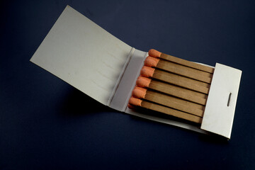 Flat wooden matchbook with orange heads matchsticks