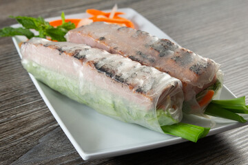 A view of a plate of sausage spring rolls.