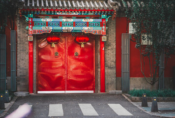 A weathered, grey-toned Beijing street scene reveals an aged building with repetitive, symmetrical window patterns, suggesting a historical urban snapshot of classic architecture.