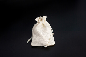 Small canvas drawstring bag on black background