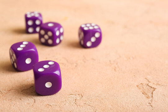 Purple dices on beige background