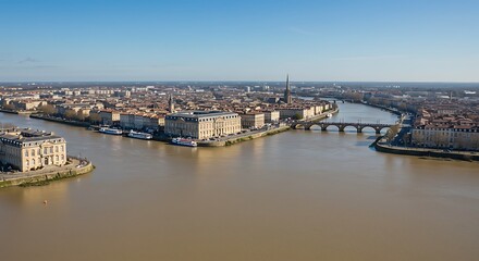 Obraz premium Aerial view of a river flowing through a large city on a sunny day