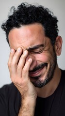 Fototapeta premium Expressive portrait of a bearded man laughing or crying intensely.