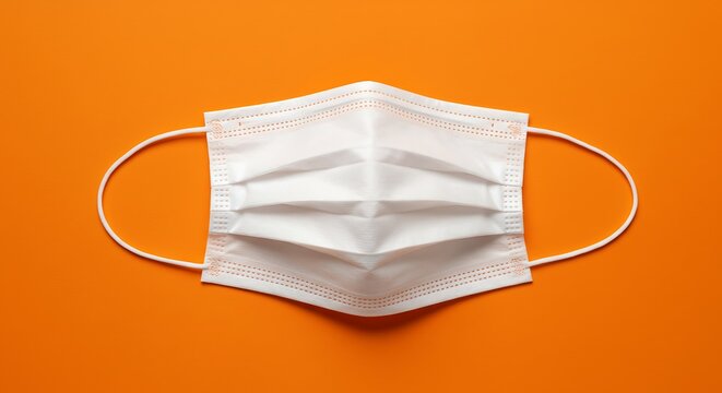 White medical mask isolated on orange background for healthcare concept
