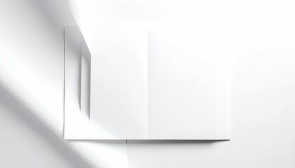 Overhead shot of a folded white paper on a bright white surface, with shadows