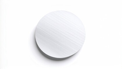 A stark white, circular object with subtle diagonal line textures rests on white