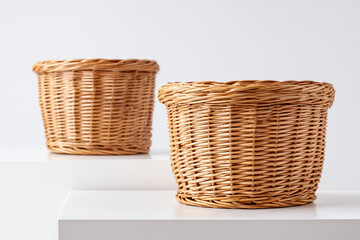 Hand craft empty wicker baskets of different sizes arranged together on podium isolated on white background, Rattan basket on display show podium.