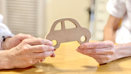 車の小物を2人で持つ女性と高齢女性