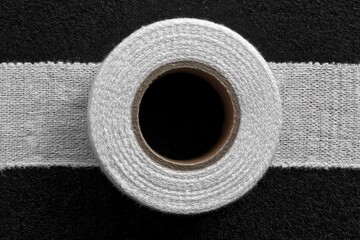 Roll of shiny silver foil tape for ductwork insulation and repair projects around the house and industrial applications on a white surface